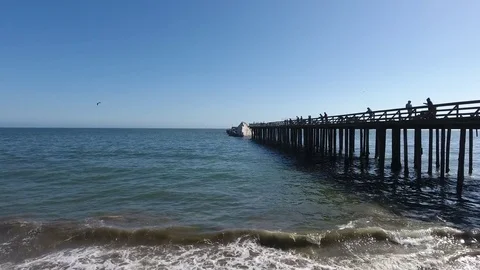 Sunken Ship Next to an Old Dock with fishermen Stock Footage 78693102