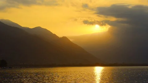 Sunlight and Clouds over Alpine Lake with Mountain Vídeo Stock 111311655
