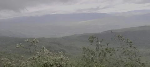 Sunlight and rain over lush green valley landscape Stock-Footage 329072498