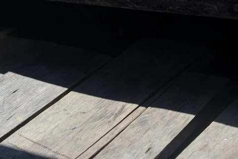 Sunlight and Shadow Across Weathered Wooden Planks Фото