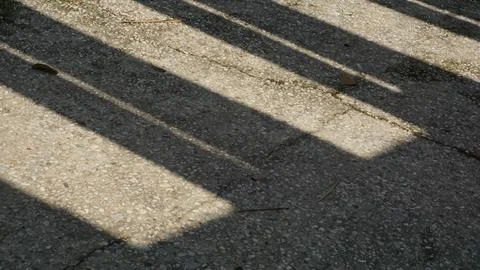 Sunlight and Shadow Patterns on City Park Pillars Stock Photos