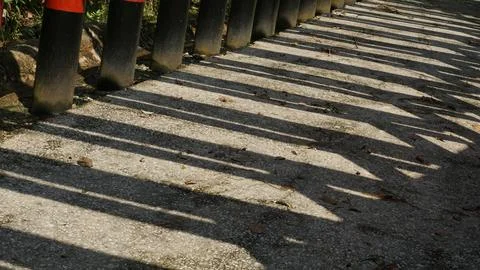 Sunlight and Shadow Patterns on City Park Pillars Stock Photos
