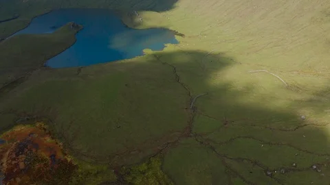 Sunlight and shadows on green slopes of Caldeirao volcano. Aerial of Corvo Stock Footage 119600454
