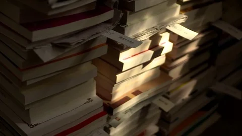 Sunlight and shadows play on stacked books Stock Footage
