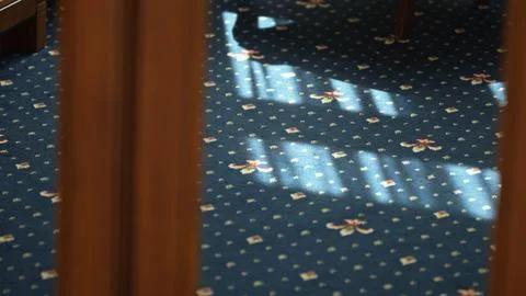 Sunlight and shadows playing on blue patterned carpet Stock Photos