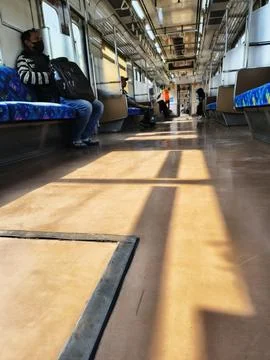 Sunlight and window shadows on the floor of a moving commuter train. Stock-Fotos