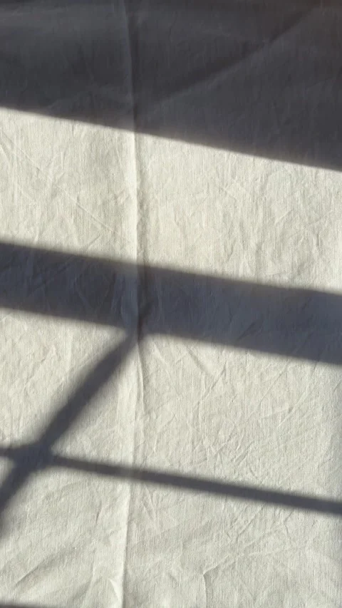 Sunlight and window shadows on white linen bed sheets Stock Footage 330492574