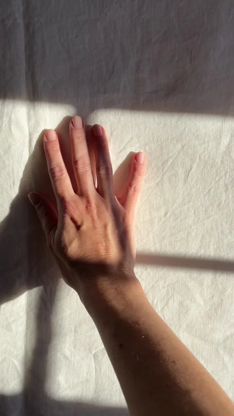 Sunlight and window shadows on white linen bed sheets Stock Footage 330492576