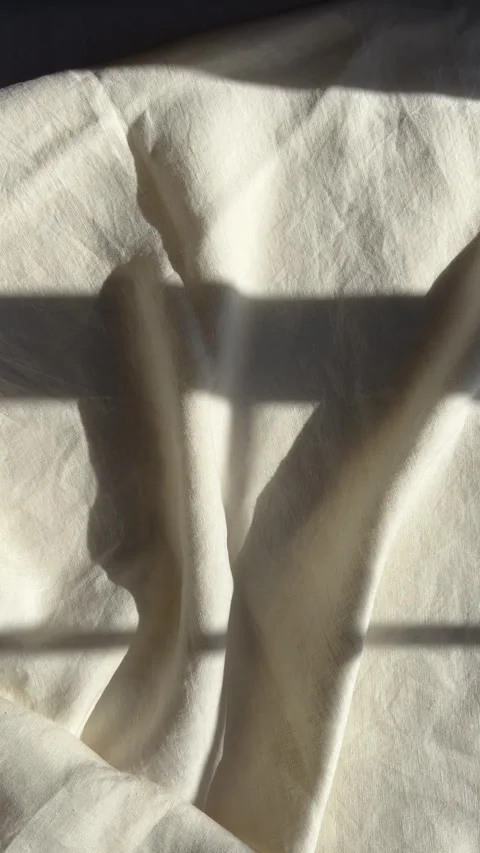 Sunlight and window shadows on white linen bed sheets Stock Footage 330492614