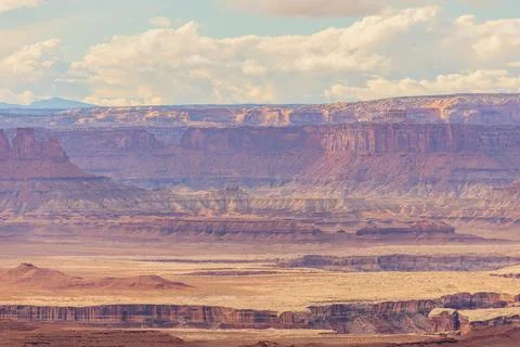 Sunlight bathes distant canyon layers under blue skies 스톡 사진