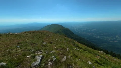 Sunlight bathes a grassy ridge, dotted with stones. Mount Rtanj, Serbia Stockbeeldmateriaal 342314702