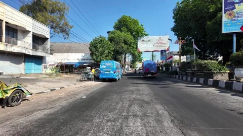 Sunlight bathes quiet street lined with shops 스톡 동영상 345138987