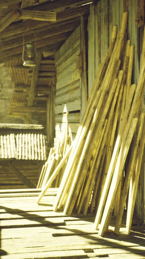 Sunlight bathes rustic wooden sticks on a weathered porch at an old barn Stock Footage 331831636