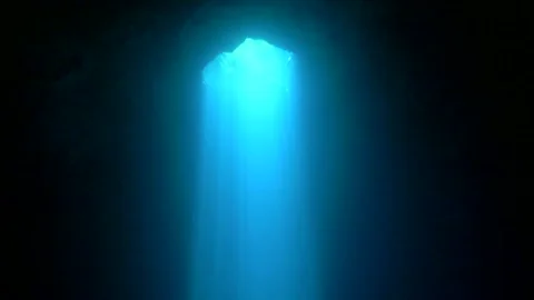 Sunlight beam descending through dark cenote water Stock Footage 341395179