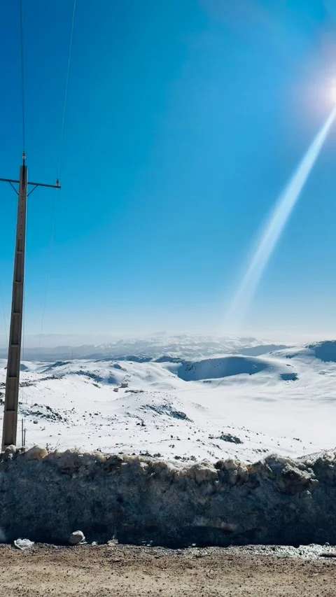 Sunlight beam shining over snowy mountains, vertical view Stock Footage 345155151