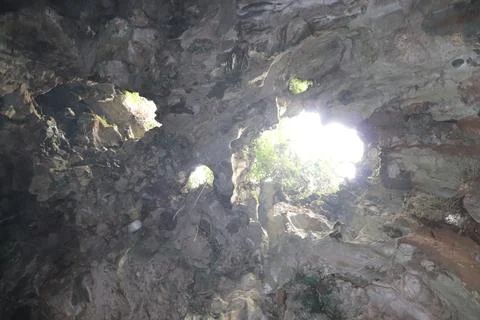 Sunlight Beaming Through a Rocky Cave Ceiling 스톡 사진