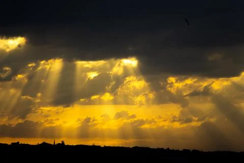 Sunlight beams in the clouds at sunset Stock Photos