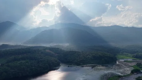Sunlight beams pierce cloud cover above mountain peaks Vídeos de archivo 344821576