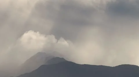 Sunlight Beams through Stormclouds over Mountains Stock Footage 8928339