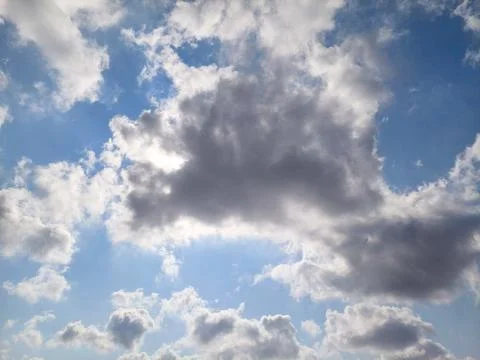 Sunlight Behind Cumulus Clouds Against Bright Blue Sky Stock Photos