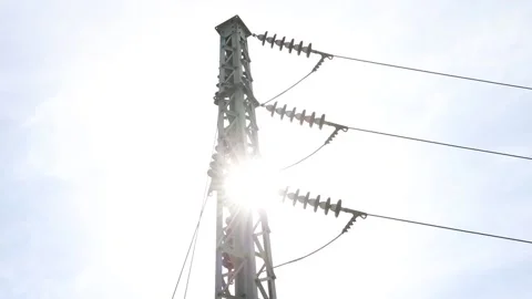 Sunlight behind high voltage electrical tower Stock Footage 162758415