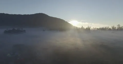 Sunlight behind the mountains with thick fog in the morning Stock Footage 296262381