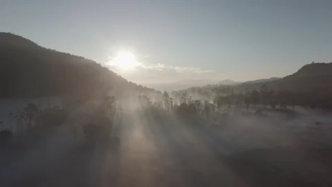 Sunlight behind the mountains with thick fog in the morning Stock Footage 296265076