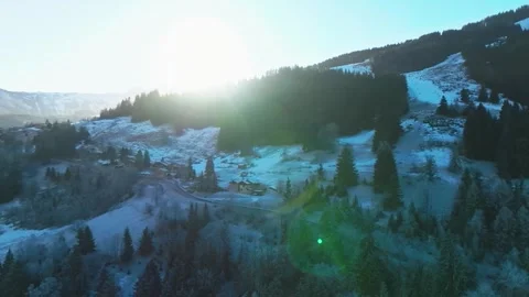 Sunlight Breaking Over Snowy Hillside and Forested Slopes Vidéo 334169037
