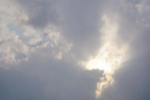 Sunlight breaking through clouds in dramatic overcast sky Stockfoto's