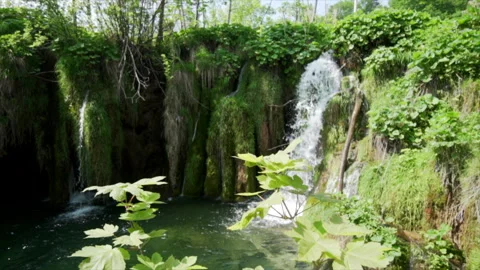 Sunlight breaking through clouds over Plitvice waterfalls Video stock 319767634