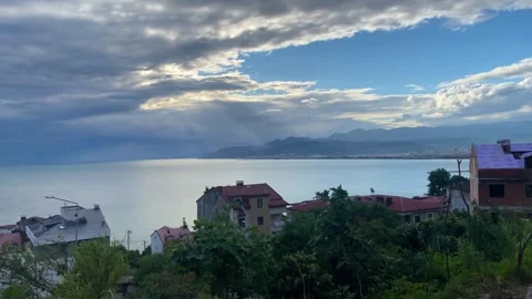 Sunlight Breaking Through Clouds Over the Sea Seen Through Trees Stock-Footage 347733104
