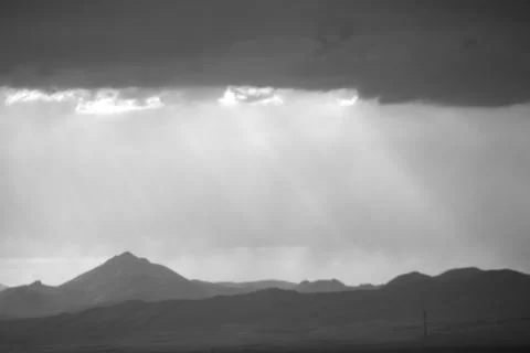 Sunlight breaking through clouds over a mountain range, perfect for backgroun Foto stock