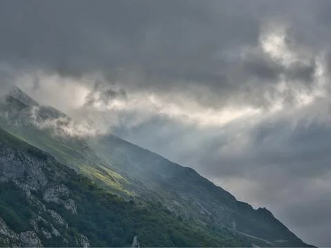 Sunlight Breaking Through Clouds Over Slope - Moody and dramatic mountain l.. Foto stock