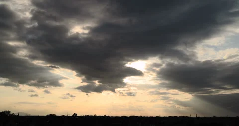 Sunlight breaking through clouds before sunset above the city Stock Footage 252675665