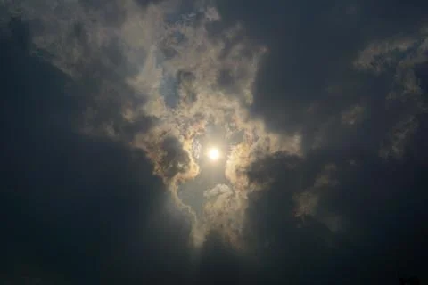 Sunlight breaking through dark storm clouds dramatic sky background Stockfoto's
