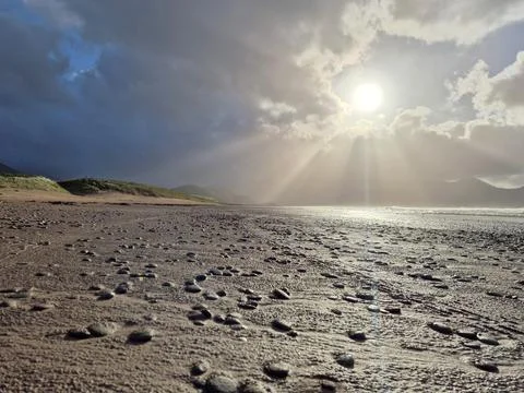 Sunlight Breaking Through Storm Clouds Over Empty Beach Stock Photos