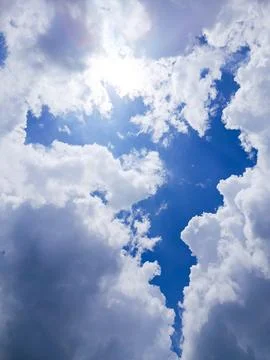 Sunlight Breaking Through White Clouds in Blue Sky Dramatic Weather Background Stock Photos