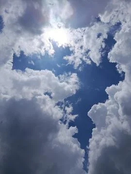 Sunlight Breaking Through White Clouds in Blue Sky Dramatic Weather Background Stock Photos
