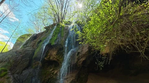 Sunlight breaks through canopy above waterfall. Balkan, Eastern Europe, POV Video stock 333587259