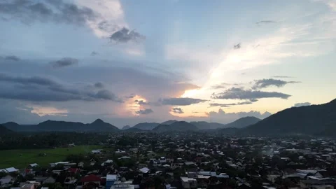 Sunlight breaks through clouds above distant hills Vídeo Stock 333602878