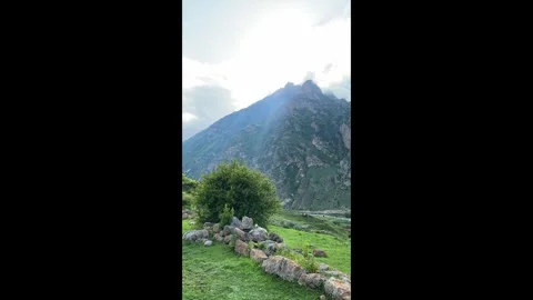 Sunlight breaks through the clouds against the background of mountain peaks Stock Footage 277183877