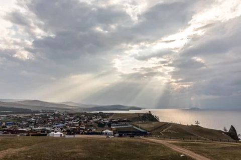 The sunlight breaks through the clouds on Lake Baikal and casts individual ra Stock Photos