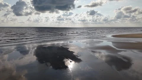 Sunlight breaks through clouds over calm sea Video stock 333033046