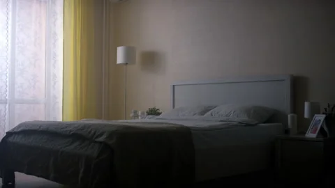 Sunlight breaks through curtains and illuminates double bed Stock Footage 231221172