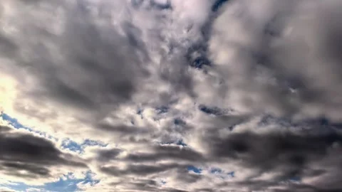 Sunlight breaks through dramatic dark clouds in time lapse, powerful weather Stock Footage 340190569