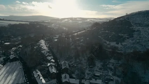 Sunlight breaks through mist over snowy hills Video stock 346849876