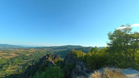 Sunlight breaks through trees atop rocky outcrop. Boracki krs Serbia 動画素材 345004894