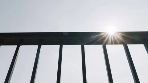 Sunlight bursts through fence bars Concept of freedom and hope Stock Footage 316269565