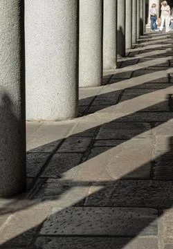 Sunlight carves a bold, geometric path through this Covent Garden colonnade.. Stock Photos