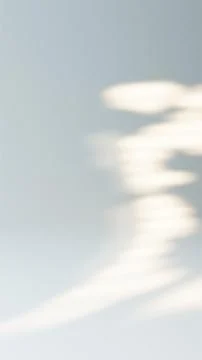 Sunlight casting a blurred window blinds shadow moving on a plain gray wall Stock Photos